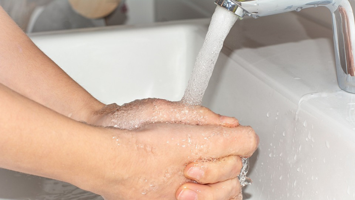 Боль от холодной воды. Кран с водой. Моем руки с мылом. Девушка моет руки с мылом.