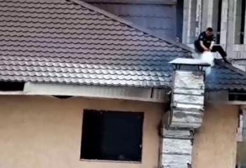 Патрульный полицейский залез на дымящуюся крышу дома и начал тушить пожар в Астане