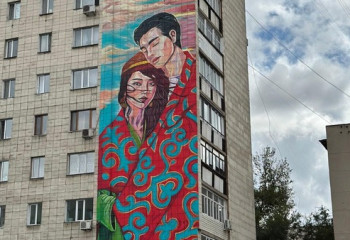 Влюблённая пара украшает один из домов Караганды